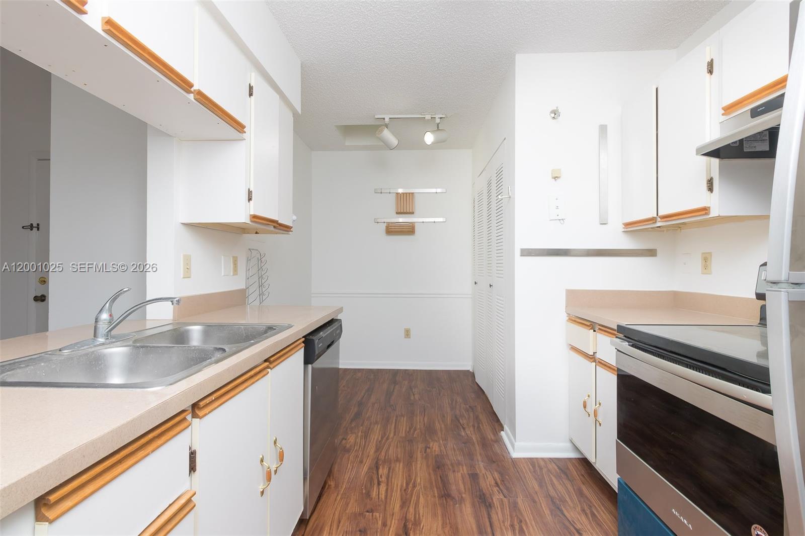 18310 Northwest 68th Avenue, Unit L Hialeah, FL 33015 - Photo 2 of 21 a kitchen with a sink stove top oven and cabinets