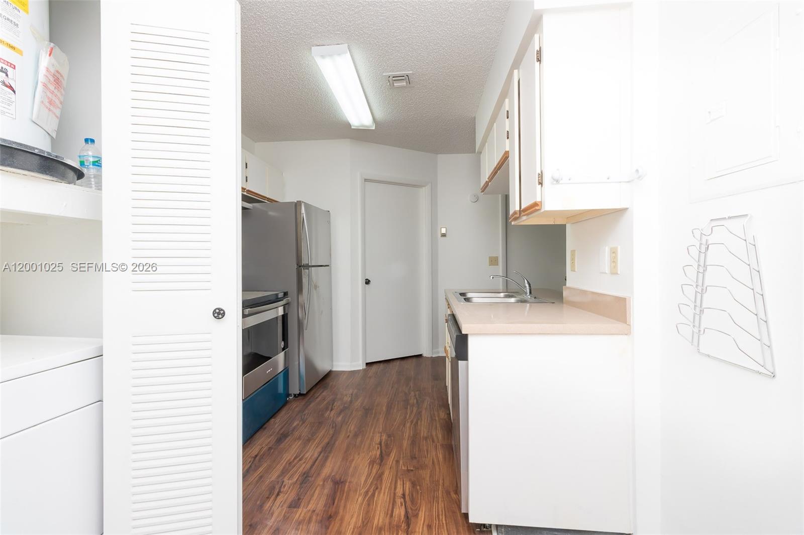 18310 Northwest 68th Avenue, Unit L Hialeah, FL 33015 - Photo 3 of 21 a kitchen with a refrigerator and a stove