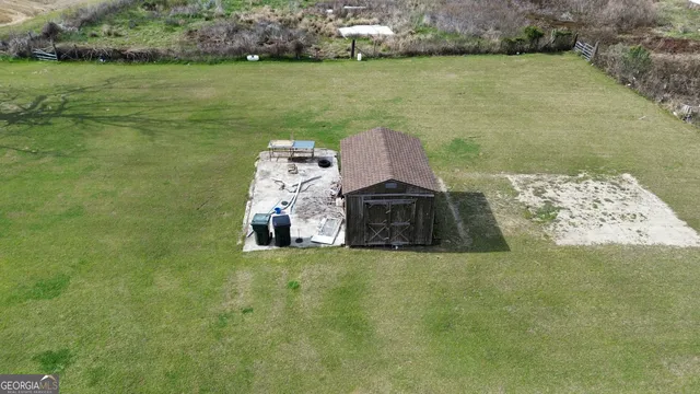 a aerial view of a house next to a yard with big trees