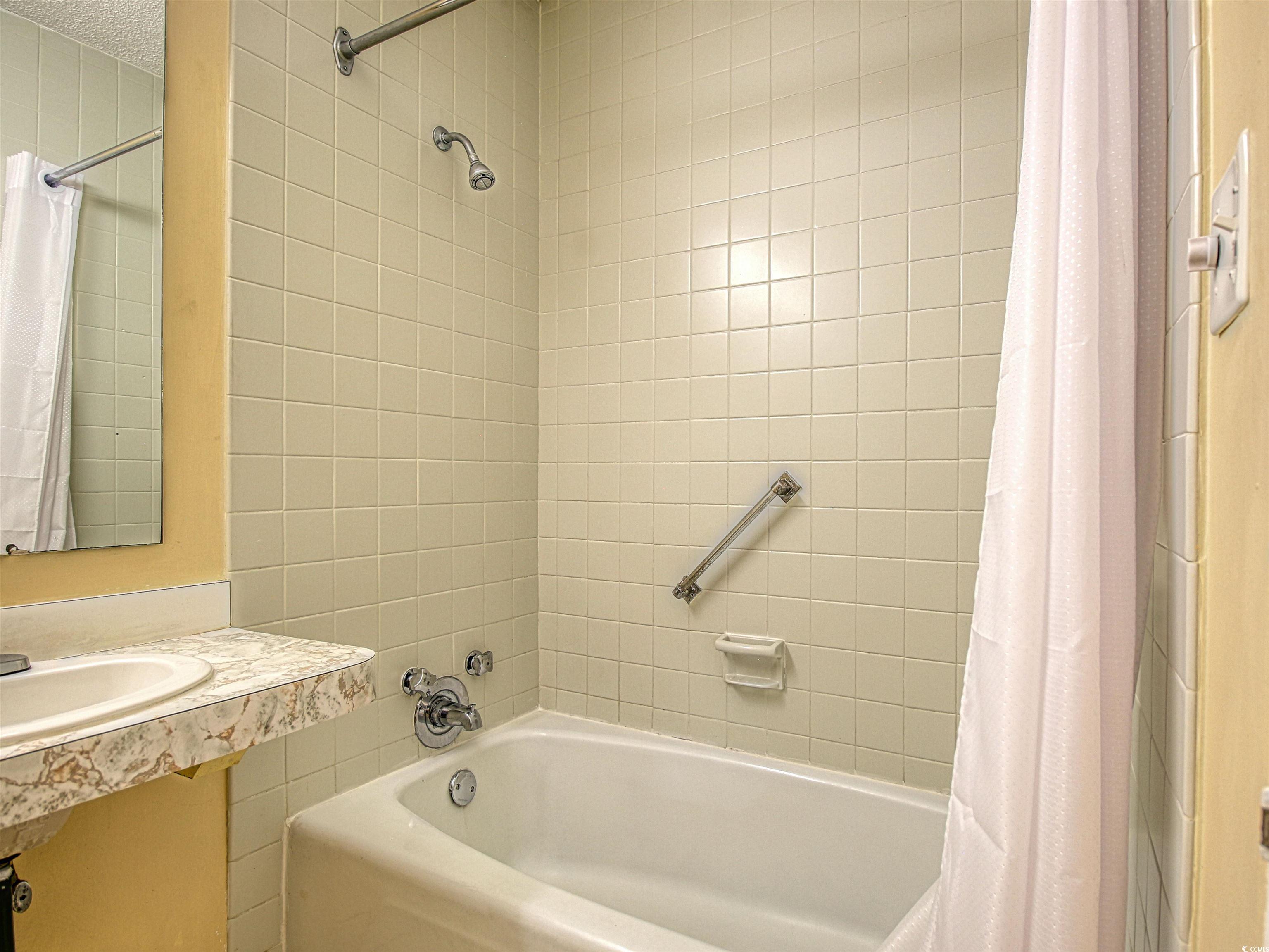 6803 North Ocean Boulevard, Unit 314 Myrtle Beach, SC 29572 - Photo 11 of 19 Bathroom featuring shower / bath combo and vanity