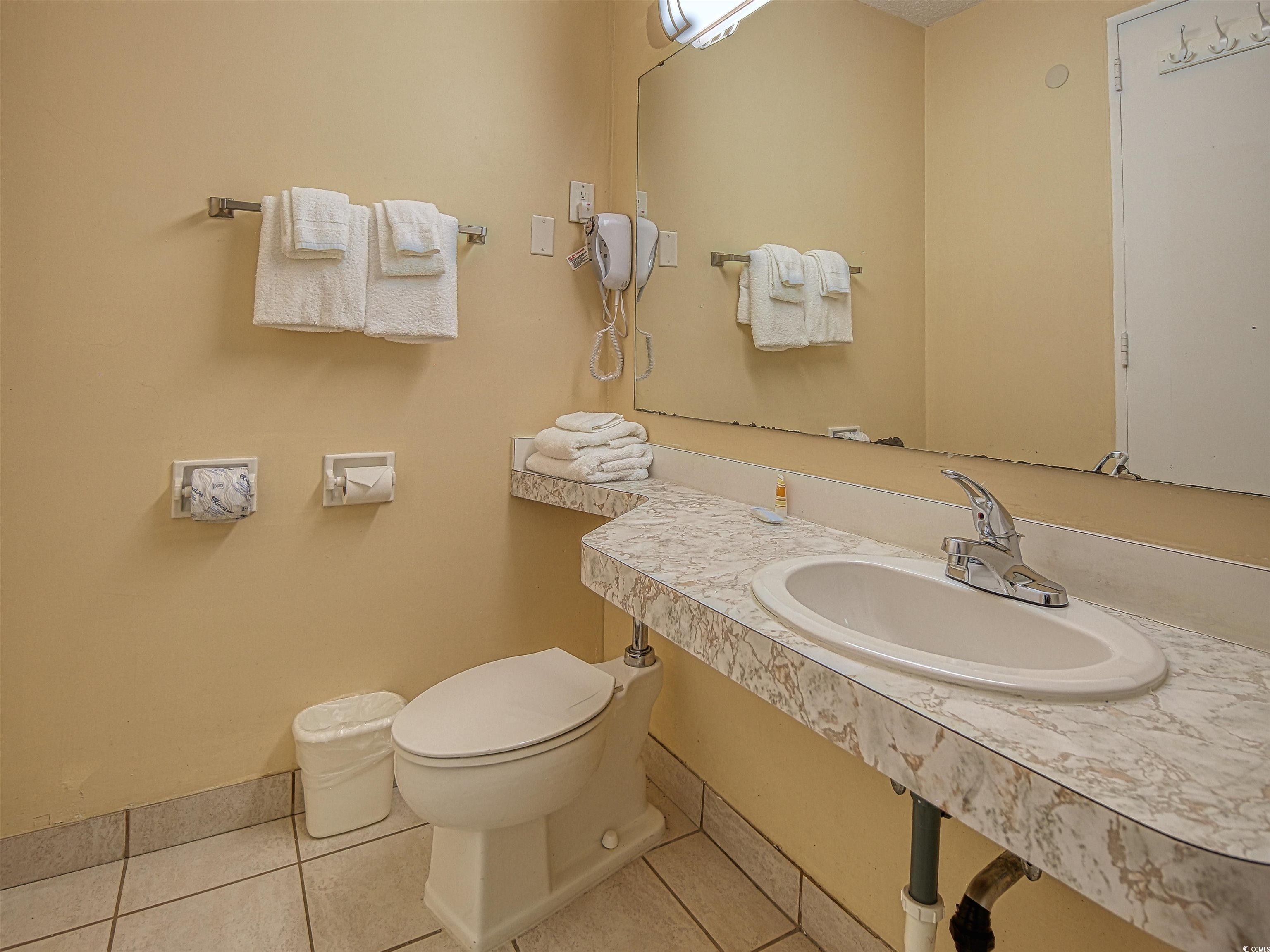 6803 North Ocean Boulevard, Unit 314 Myrtle Beach, SC 29572 - Photo 12 of 19 Half bath featuring light tile patterned floors and vanity