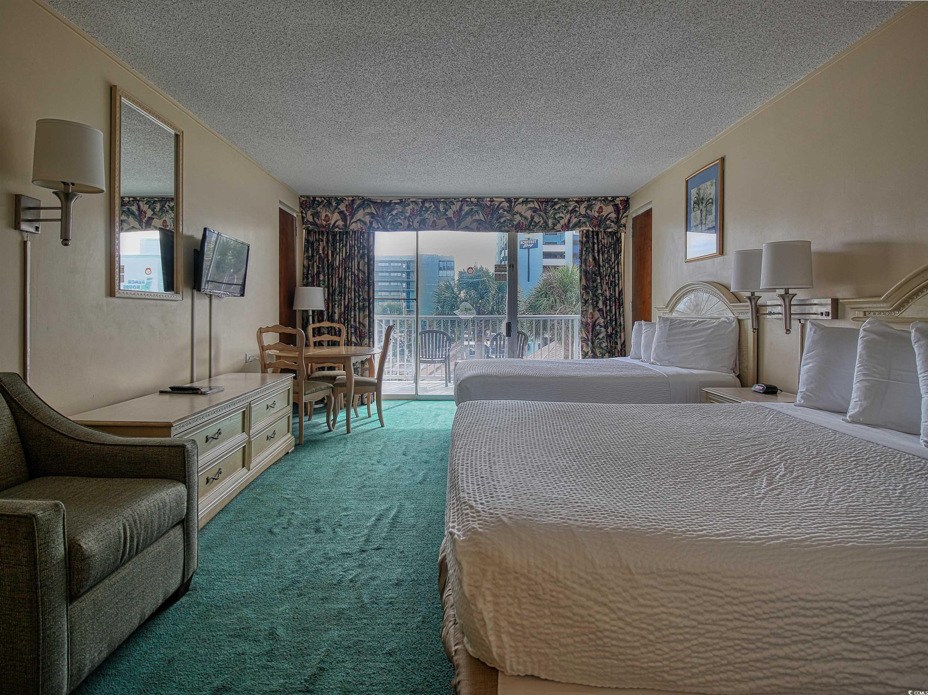 6803 North Ocean Boulevard, Unit 314 Myrtle Beach, SC 29572 - Photo 2 of 19 Bedroom featuring access to outside, a textured ceiling, carpet floors, and a sunroom