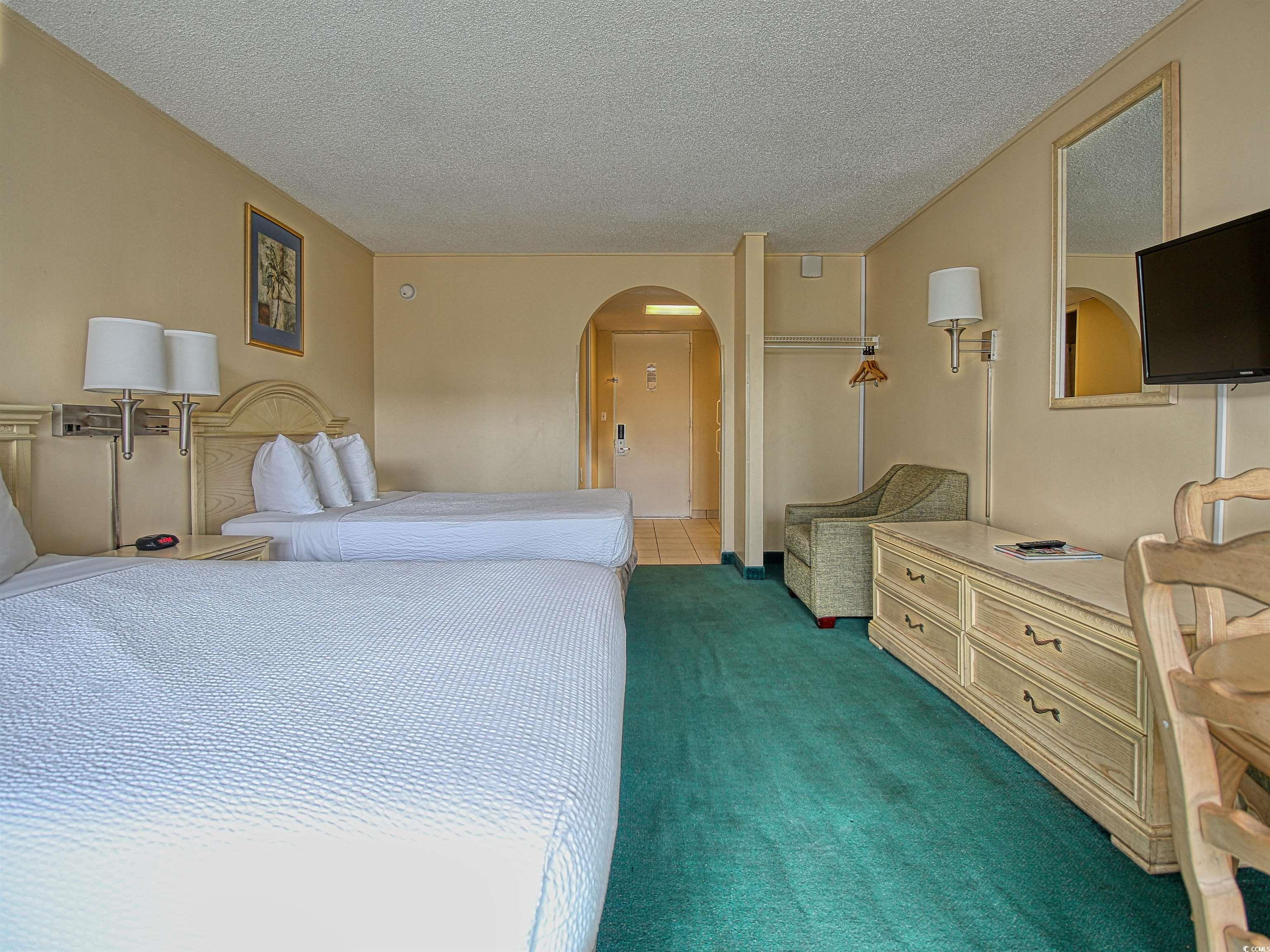 6803 North Ocean Boulevard, Unit 314 Myrtle Beach, SC 29572 - Photo 4 of 19 Bedroom with a textured ceiling, arched walkways, and dark carpet