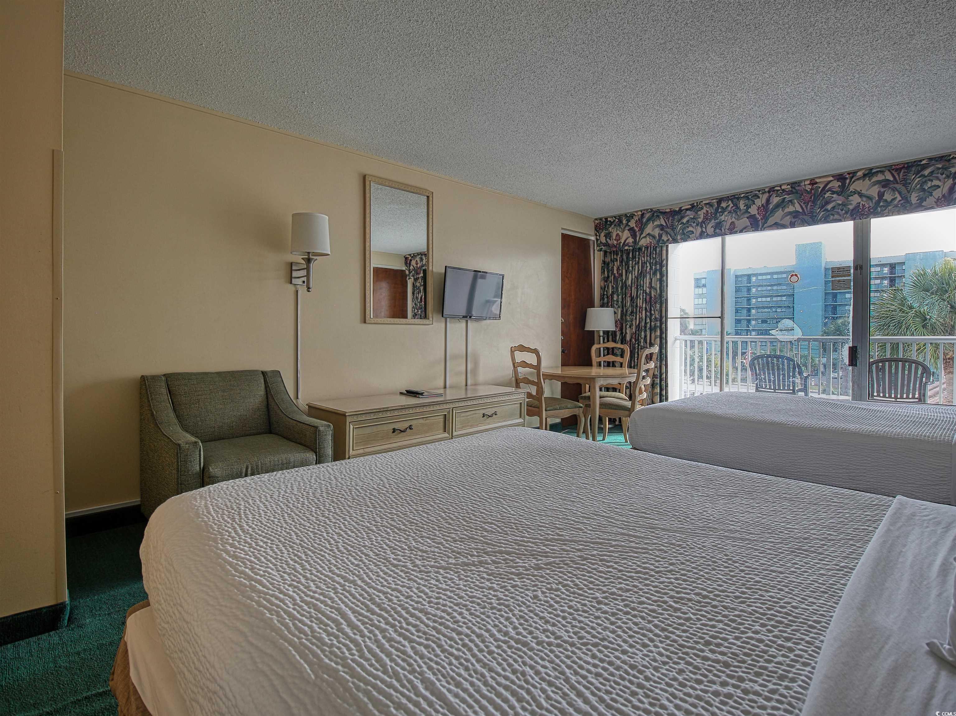 6803 North Ocean Boulevard, Unit 314 Myrtle Beach, SC 29572 - Photo 5 of 19 Carpeted bedroom with a textured ceiling and access to exterior