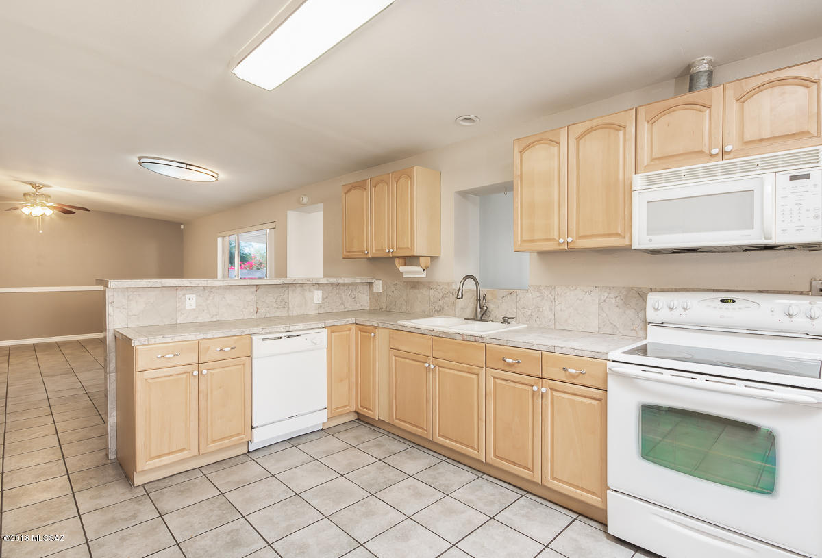 7761 North Rasmussen Avenue Tucson, AZ 85741 - Photo 5 of 23 a kitchen with white cabinets appliances and sink