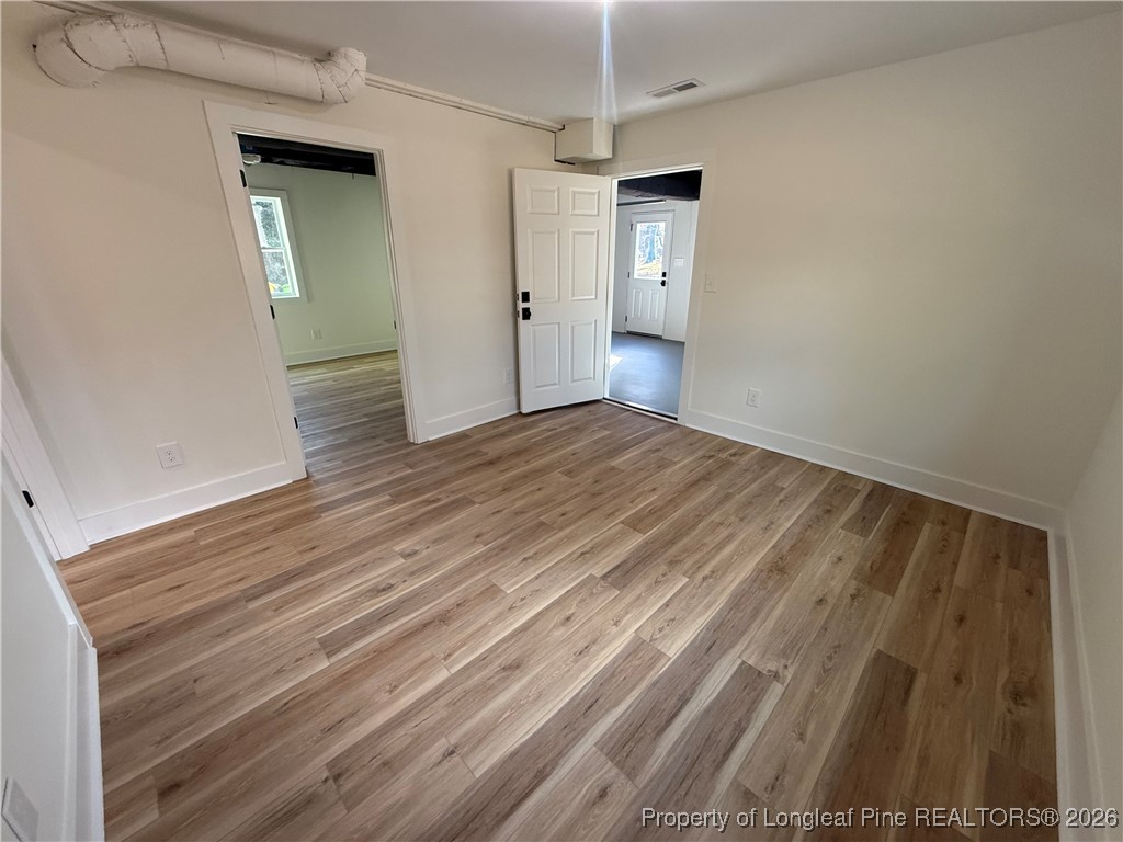 5508 Sweetbriar Drive Raleigh, NC 27609 - Photo 24 of 29 a view of an empty room with wooden floor and a window