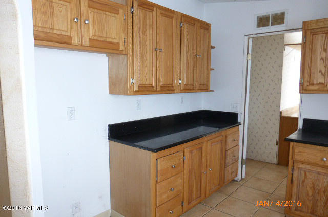 201 Mini Pines Road Yakima, WA 98903 - Photo 7 of 11 a kitchen with granite countertop white cabinets and a refrigerator
