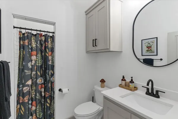 a bathroom with a toilet sink and mirror