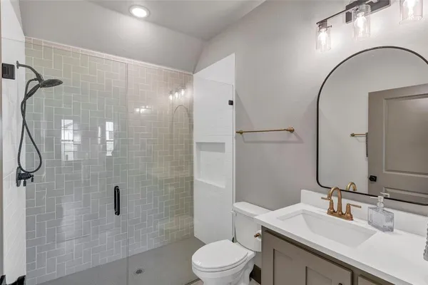 a bathroom with a sink a toilet and shower