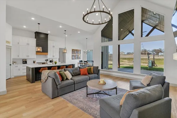 a living room with furniture kitchen and a chandelier