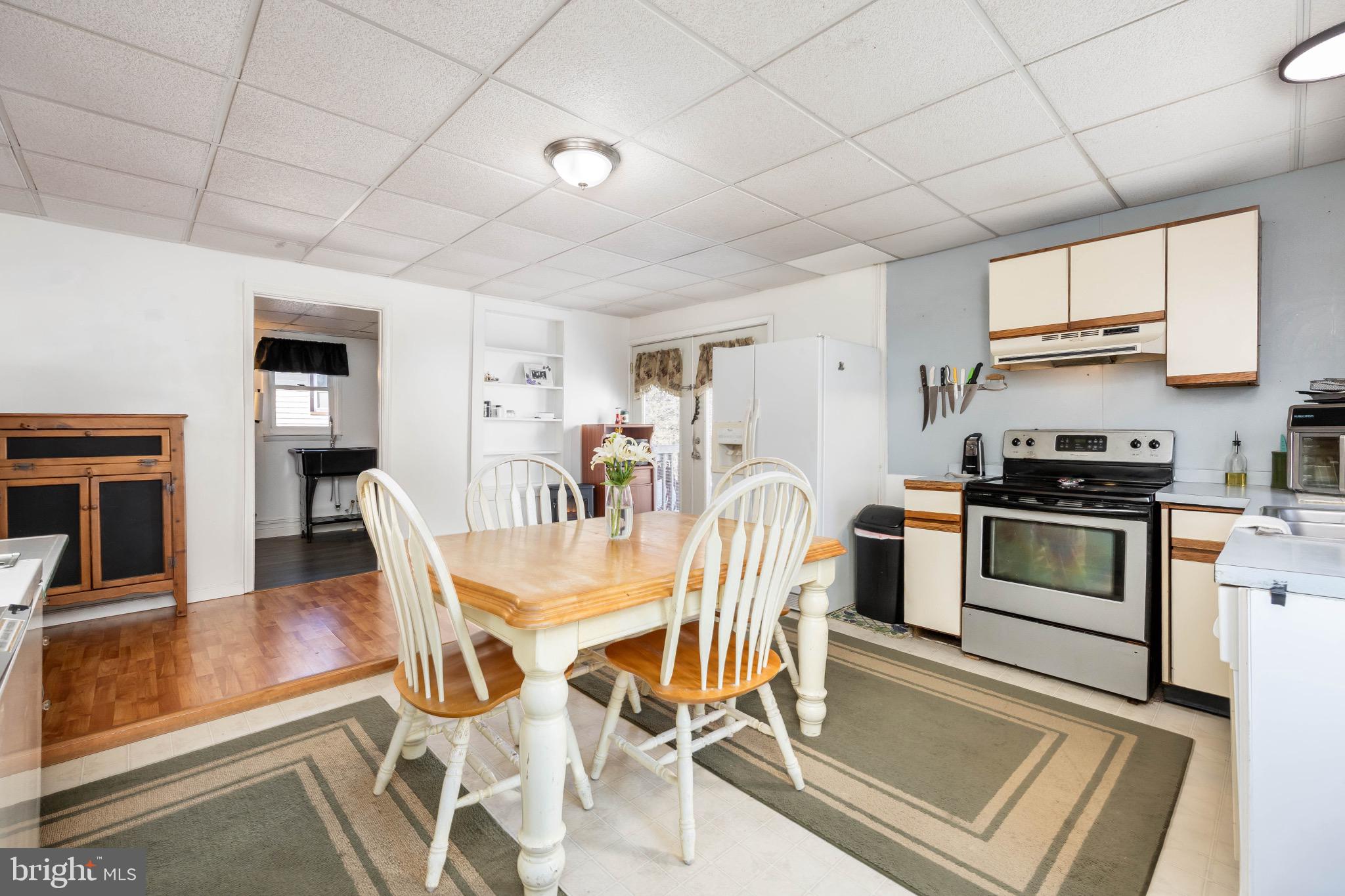 505 Main Street Mardela Springs, MD 21837 - Photo 21 of 60 a kitchen with stainless steel appliances granite countertop a stove a refrigerator a kitchen island with a dining table and chairs
