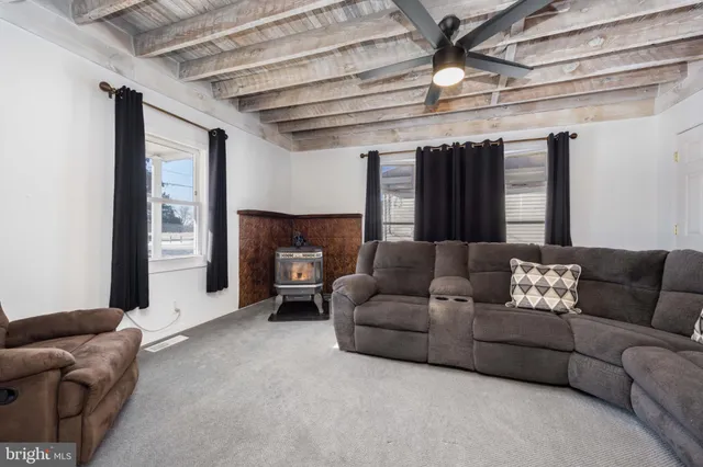 a living room with furniture ceiling fan and a window