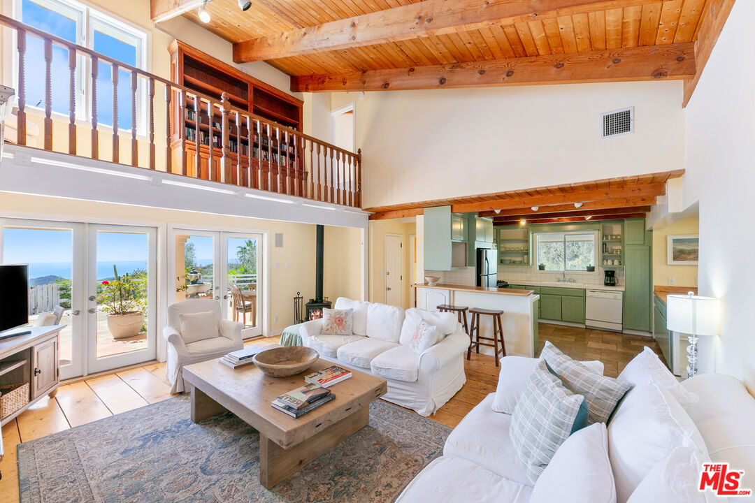 2302 Latigo Canyon Road Malibu, CA 90265 - Photo 4 of 30 a living room with furniture a flat screen tv and a table