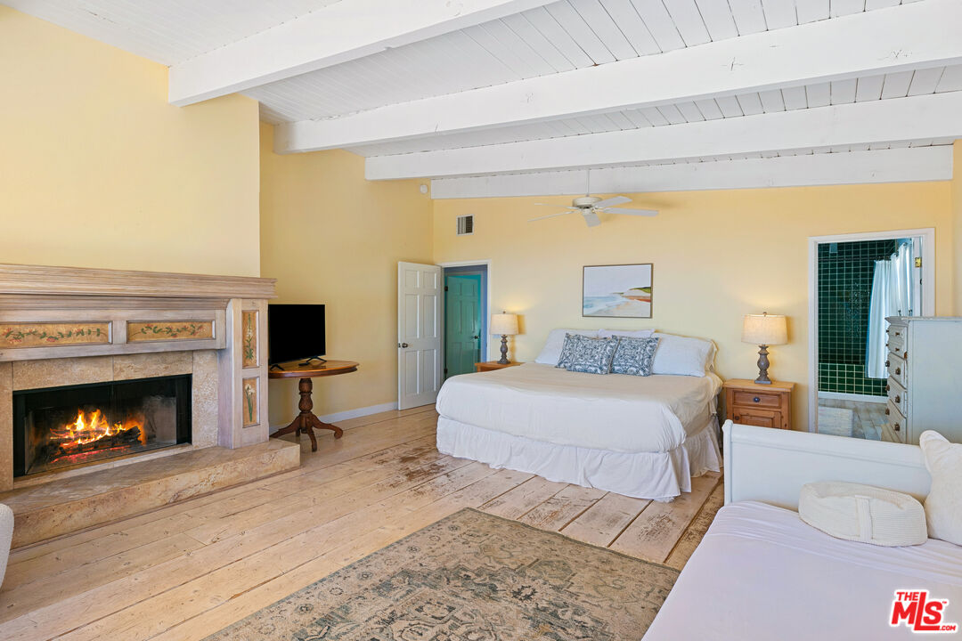 2302 Latigo Canyon Road Malibu, CA 90265 - Photo 8 of 30 a bedroom with a bed and a fireplace