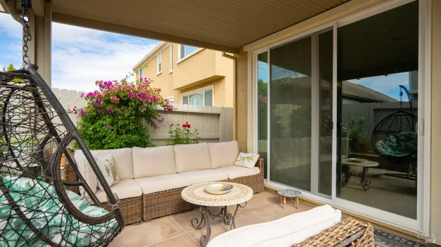 a patio with glass top table and chairs