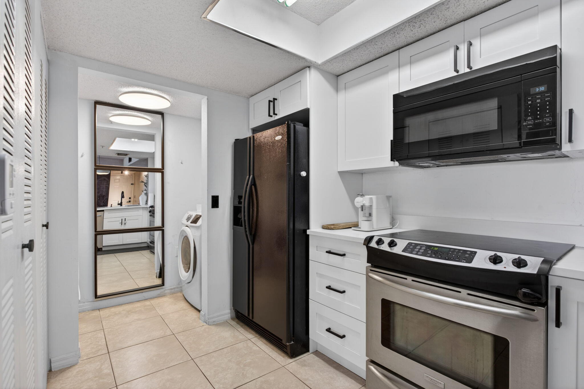 5011 Wiles Road, Unit 104 Coconut Creek, FL 33073 - Photo 14 of 43 a kitchen with a stove microwave and refrigerator