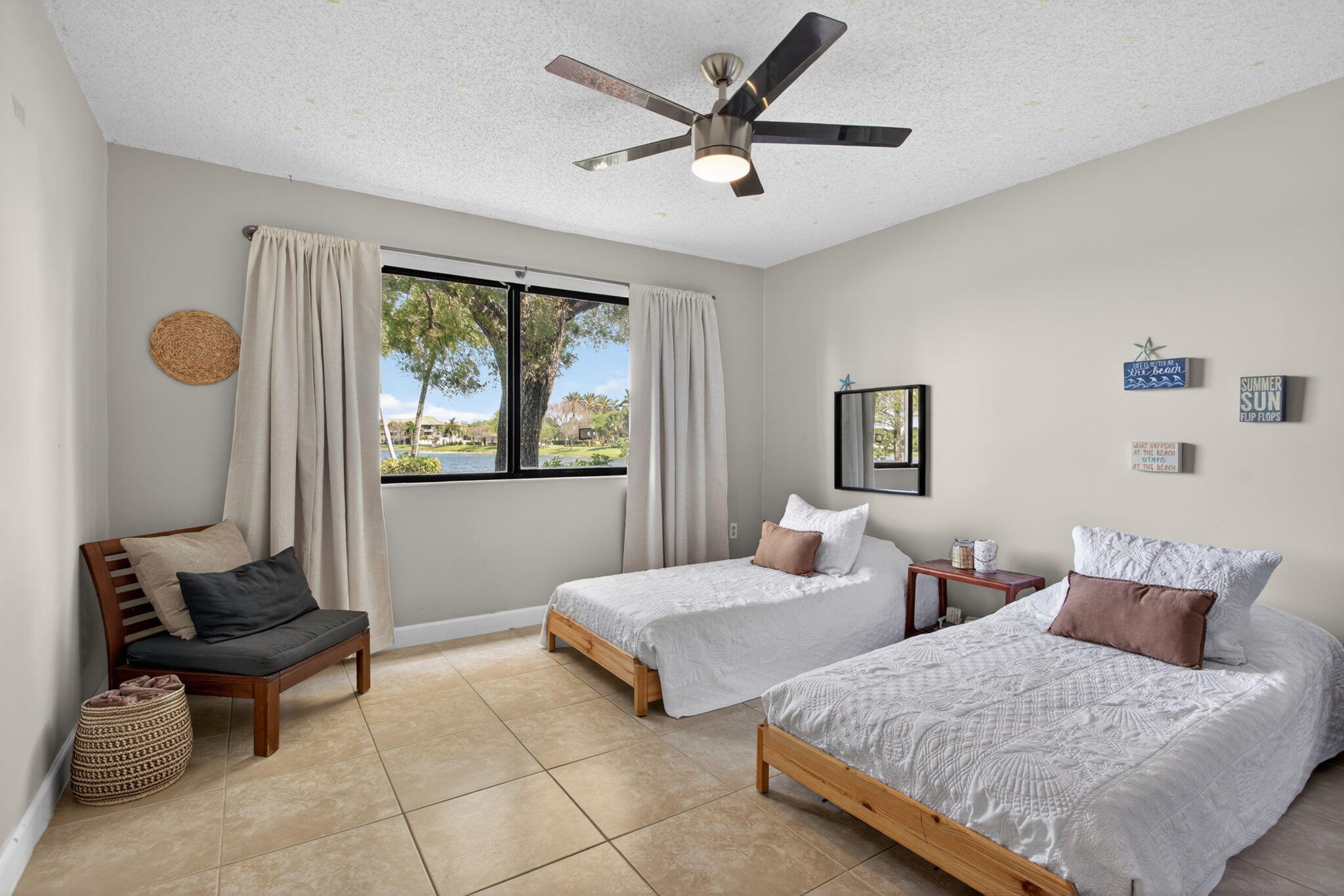 5011 Wiles Road, Unit 104 Coconut Creek, FL 33073 - Photo 17 of 43 a bedroom with two beds and a large window