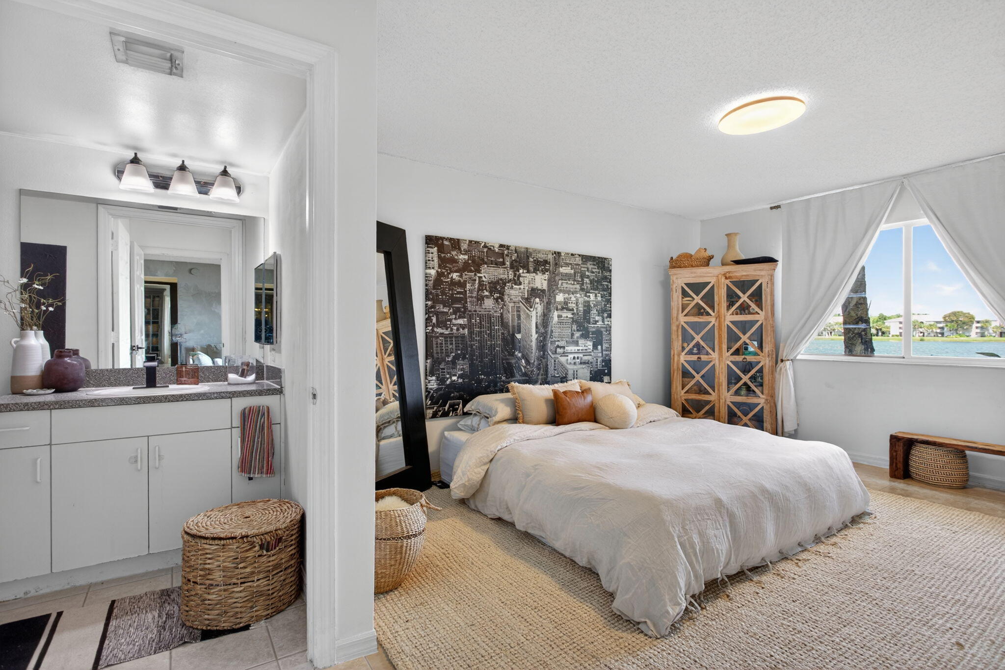 5011 Wiles Road, Unit 104 Coconut Creek, FL 33073 - Photo 22 of 43 a bedroom with a bed and a chandelier