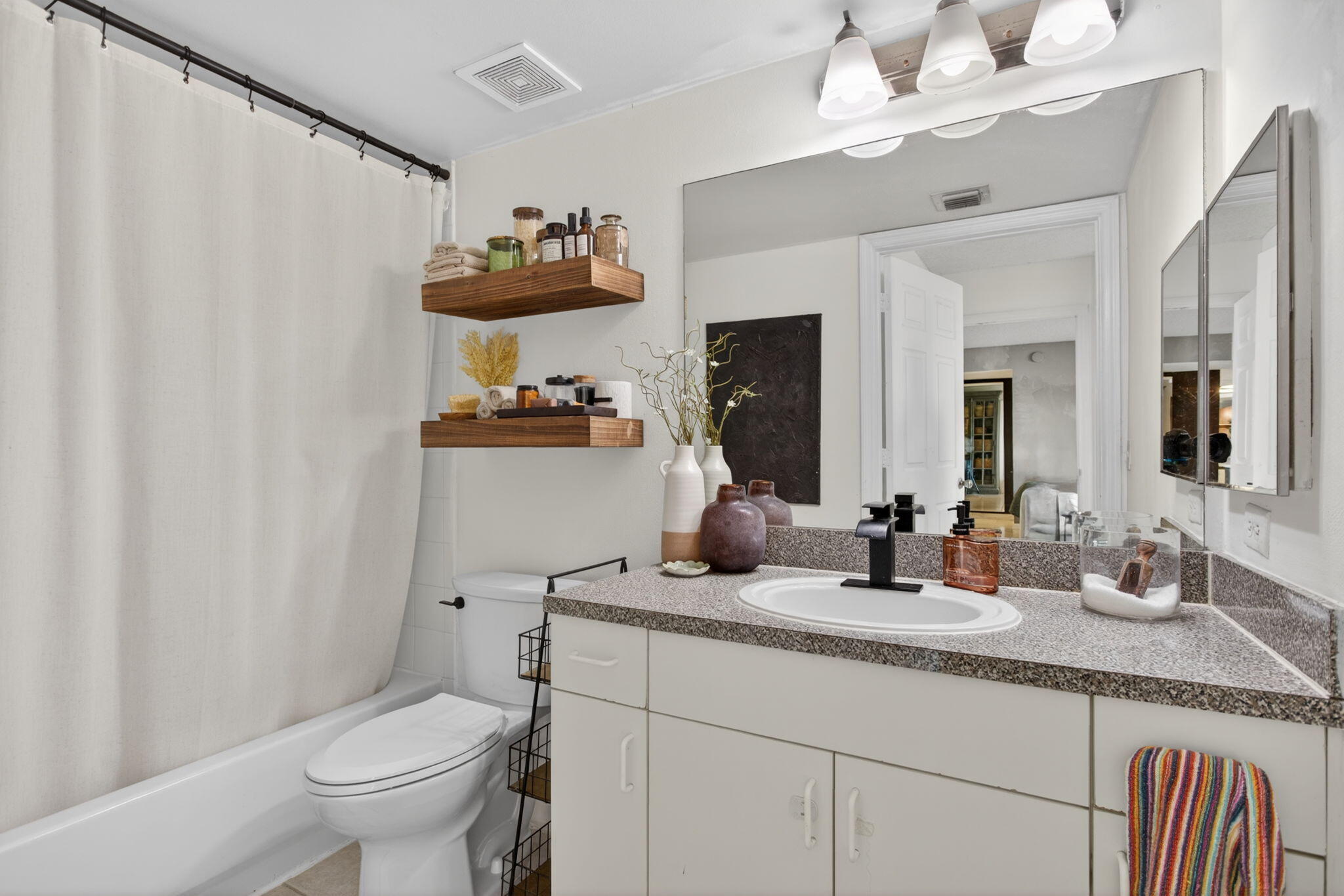 5011 Wiles Road, Unit 104 Coconut Creek, FL 33073 - Photo 26 of 43 a bathroom with a granite countertop sink a toilet and a mirror