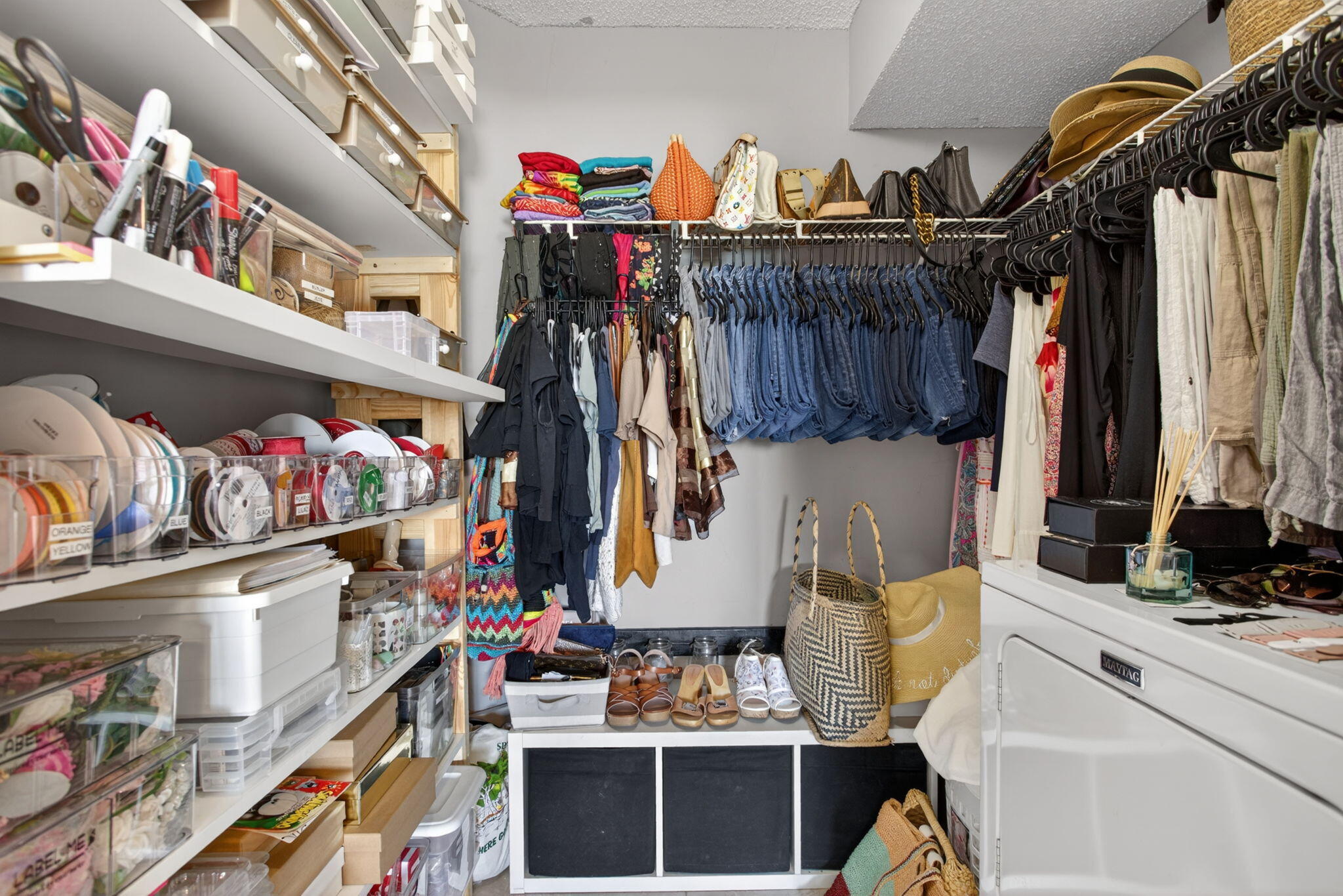 5011 Wiles Road, Unit 104 Coconut Creek, FL 33073 - Photo 27 of 43 a view of walk in closet with clothes and shoes