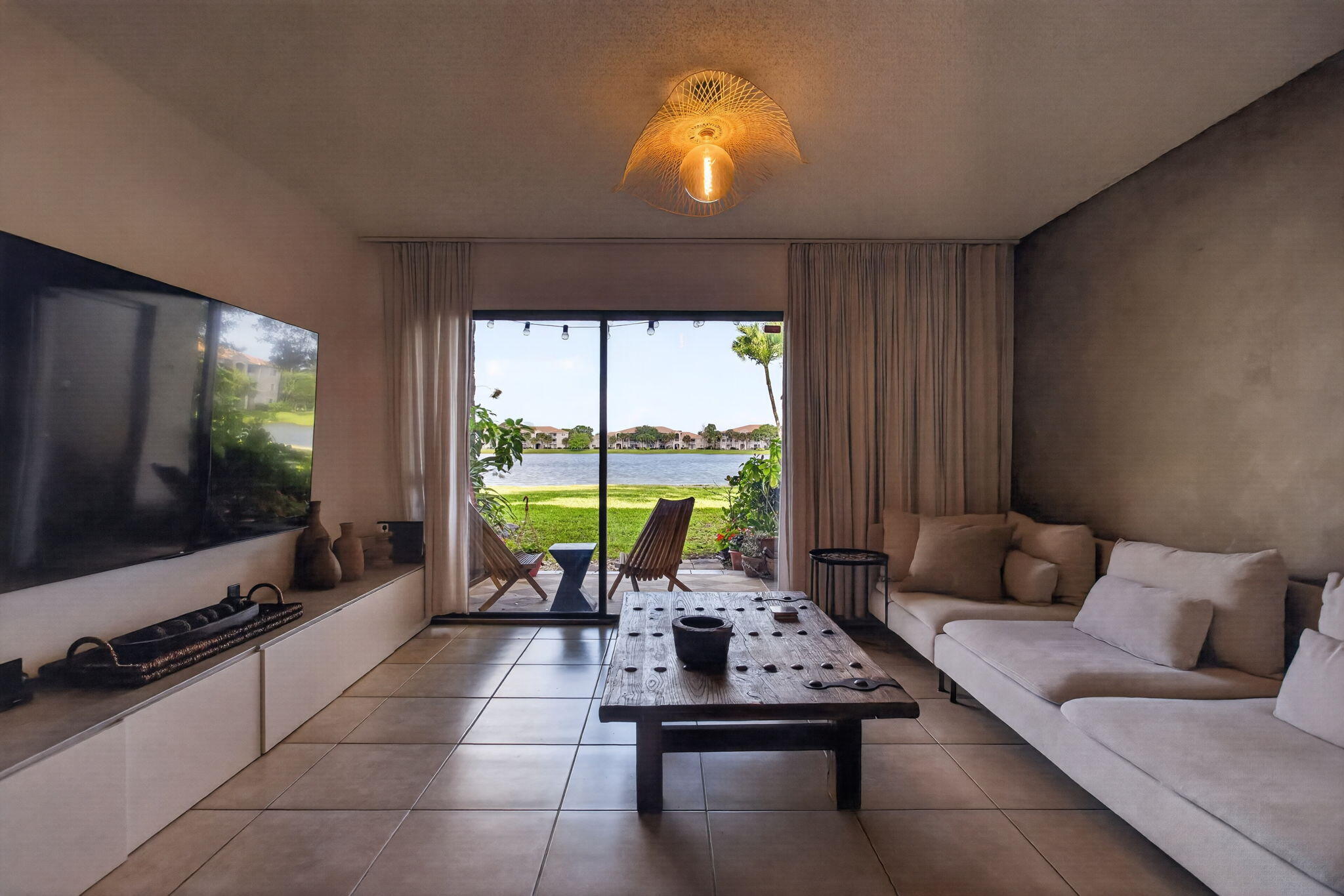 5011 Wiles Road, Unit 104 Coconut Creek, FL 33073 - Photo 29 of 43 a living room with furniture and a flat screen tv