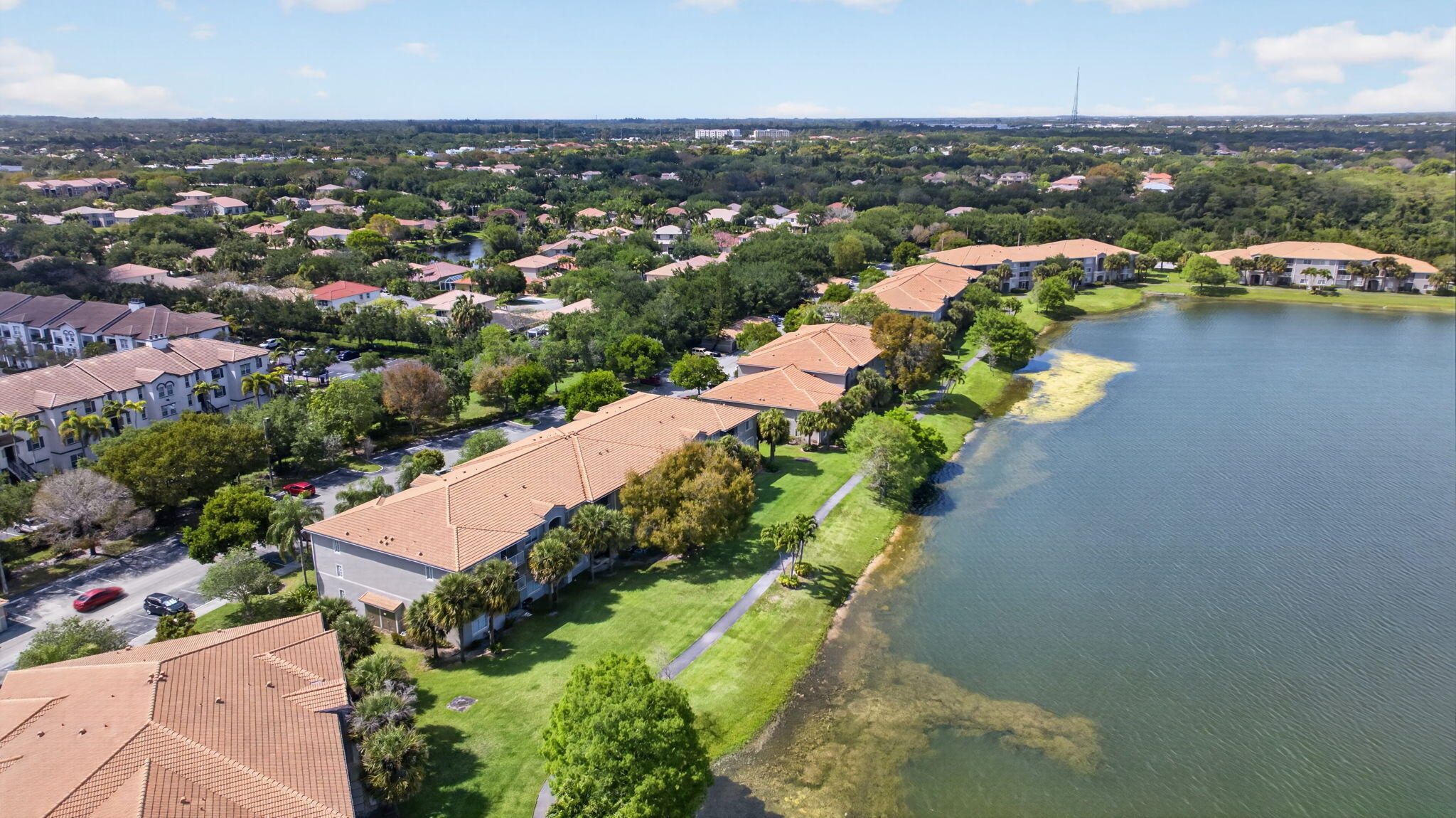 5011 Wiles Road, Unit 104 Coconut Creek, FL 33073 - Photo 32 of 43 an aerial view of a city with lots of residential buildings ocean and mountain view in back