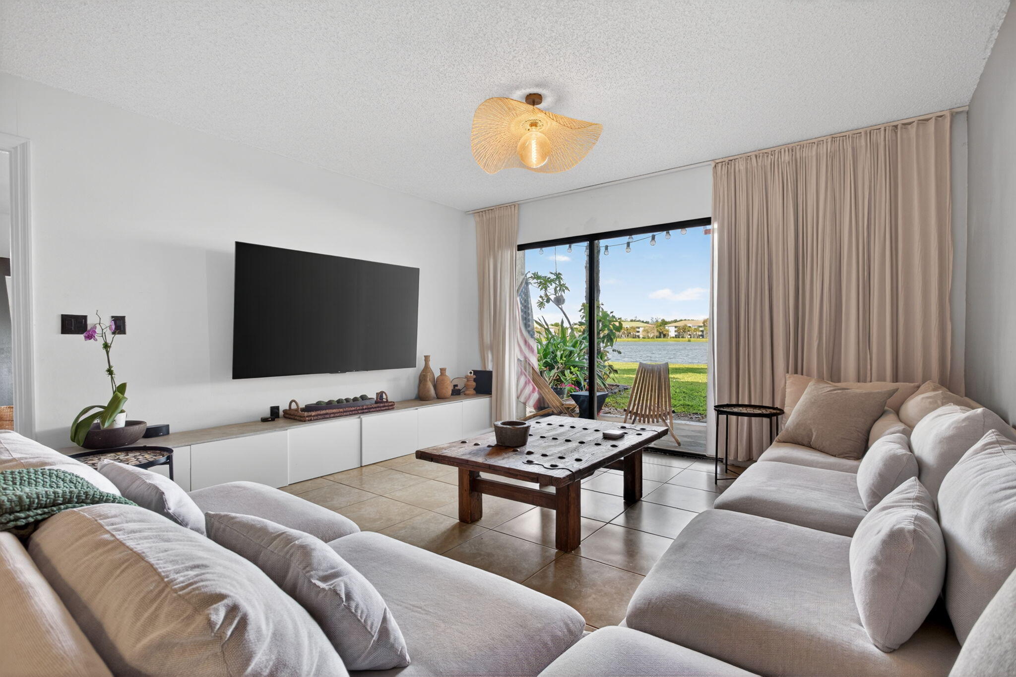 5011 Wiles Road, Unit 104 Coconut Creek, FL 33073 - Photo 10 of 43 a living room with furniture and a flat screen tv