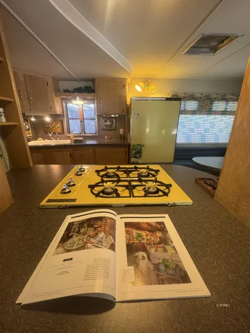 a bed sitting in a kitchen next to a window