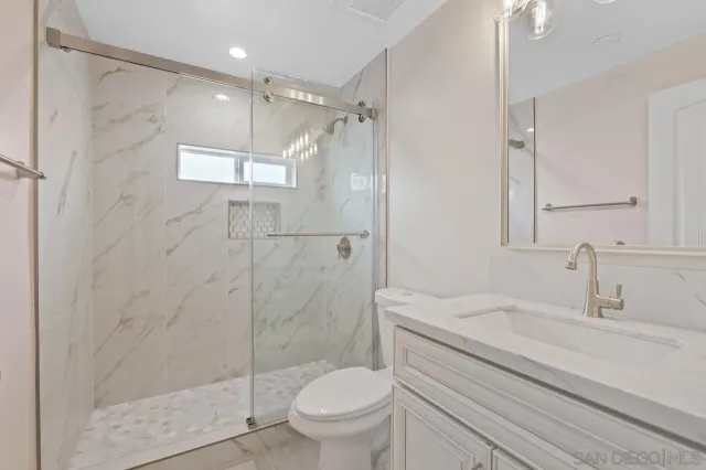 a bathroom with a sink a toilet and shower