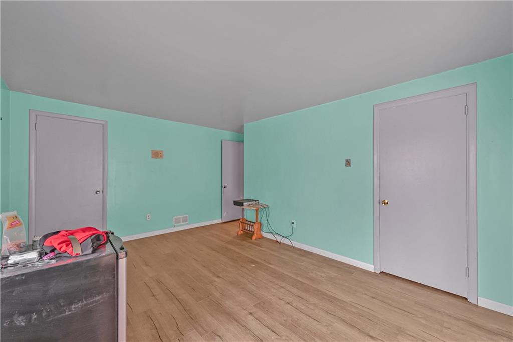 565 Upper Middletown Road Smock, PA 15480 - Photo 17 of 25 a bedroom with a bed and a wooden floor