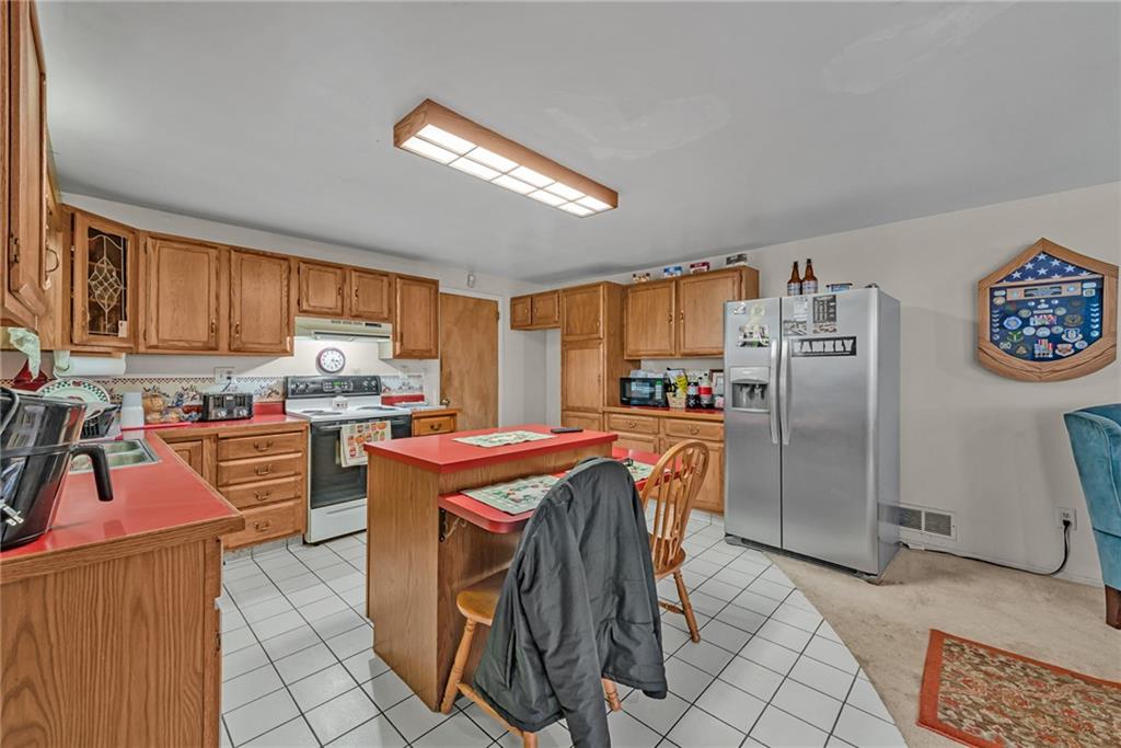 565 Upper Middletown Road Smock, PA 15480 - Photo 5 of 25 a kitchen with stainless steel appliances granite countertop a refrigerator stove top oven and a sink