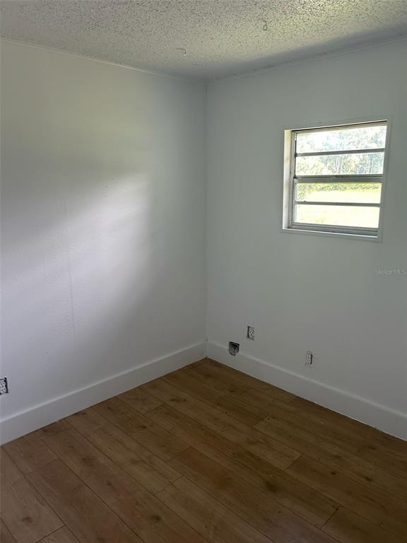 1059 South Moody Road Palatka, FL 32177 - Photo 11 of 12 an empty room with wooden floor and windows