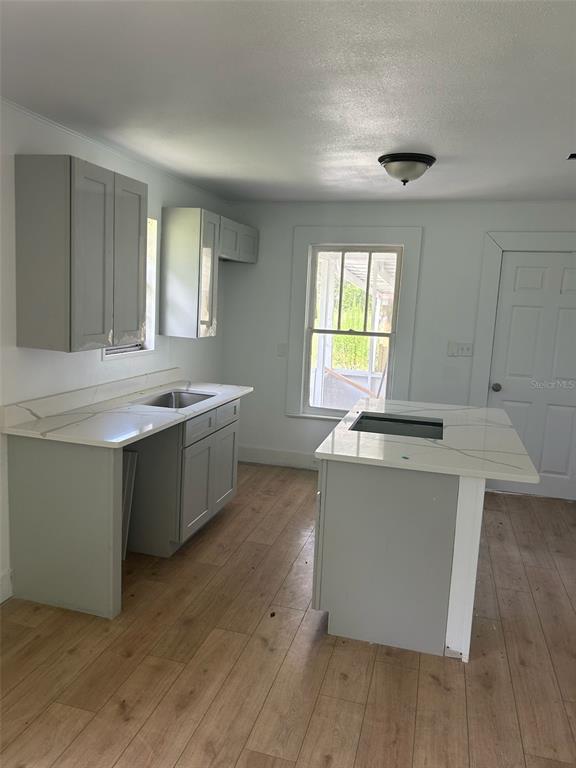 1059 South Moody Road Palatka, FL 32177 - Photo 4 of 12 a kitchen with a sink cabinets wooden floor and a window