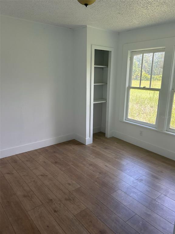 1059 South Moody Road Palatka, FL 32177 - Photo 8 of 12 an empty room with wooden floor and windows