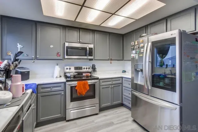 a kitchen with stainless steel appliances granite countertop a refrigerator a stove a sink and a microwave