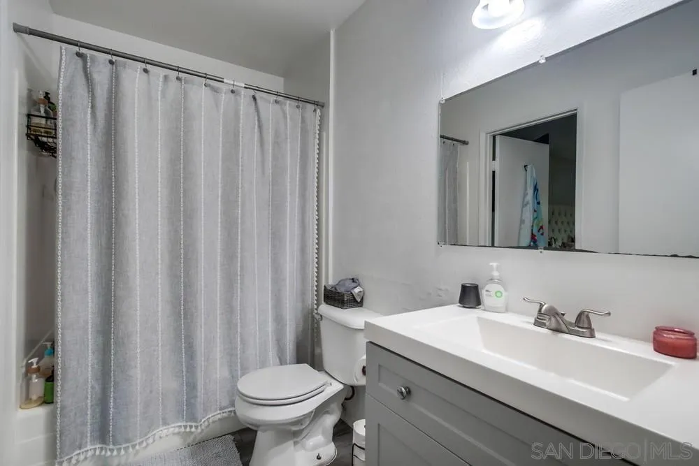 3433 Los Mochis Way Oceanside, CA 92056 - Photo 25 of 45 a bathroom with a sink a toilet and a mirror