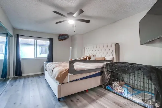 a bedroom with a bed and a flat tv screen on dresser