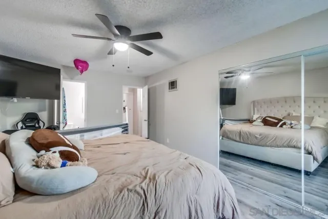a spacious bedroom with a bed couch and window