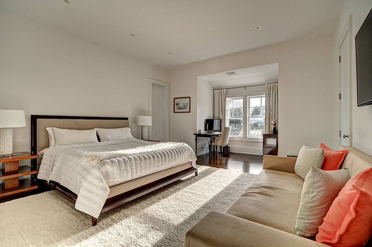 63 Newlight Lane Bridgehampton, NY 11976 - Photo 20 of 37 a spacious bedroom with a bed and glass window