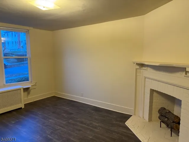 a room with wooden floor and a fireplace