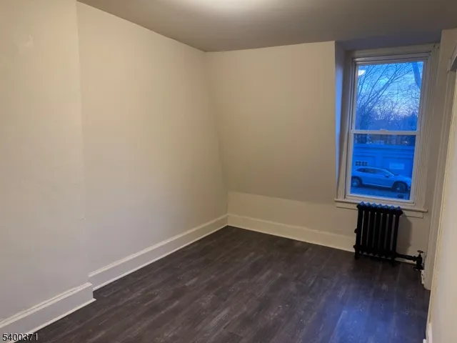 a view of a room with wooden floor and a window