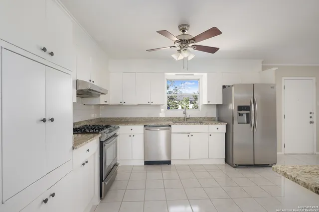 a kitchen with stainless steel appliances granite countertop a stove a sink and a refrigerator