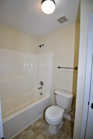 a white toilet sitting next to a bath tub and a shower