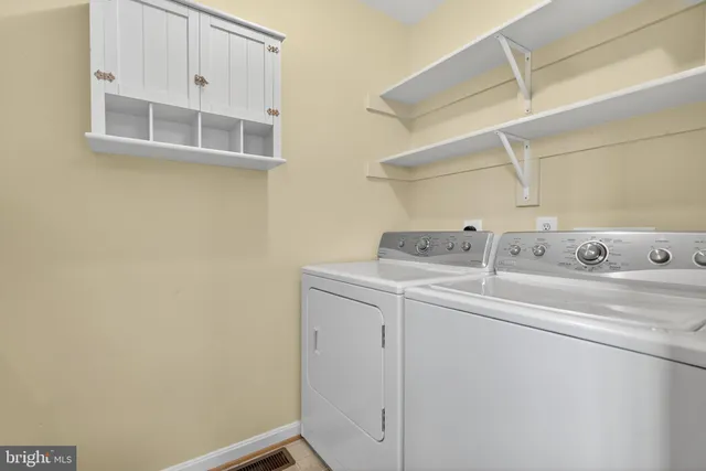 a white house with a big yard and large trees