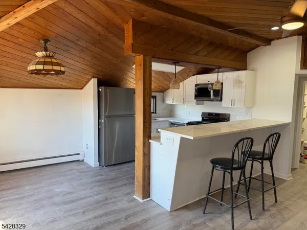 a kitchen with kitchen island a counter top space a sink stainless steel appliances and cabinets