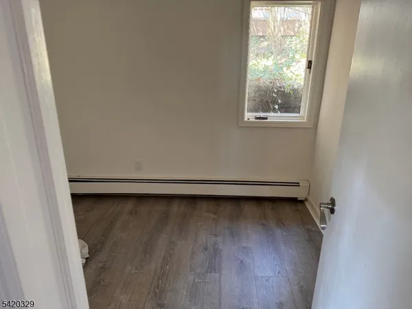 a view of a room with wooden floor and a window
