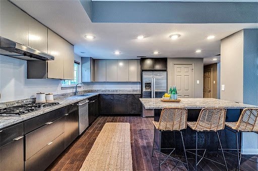 1702 Newning Avenue, Unit B Austin, TX 78704 - Photo 1 of 1 a kitchen with stainless steel appliances granite countertop a stove a sink dishwasher a dining table and chairs with wooden floor