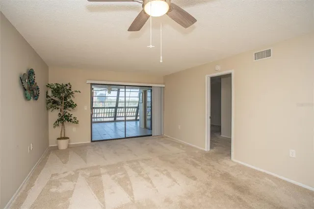 a view of a tennis ground with large trees
