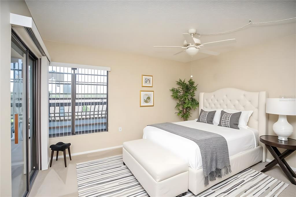 9860 62nd Avenue North, Unit 1014 St. Petersburg, FL 33708 - Photo 29 of 68 a bedroom with a large bed and a chandelier