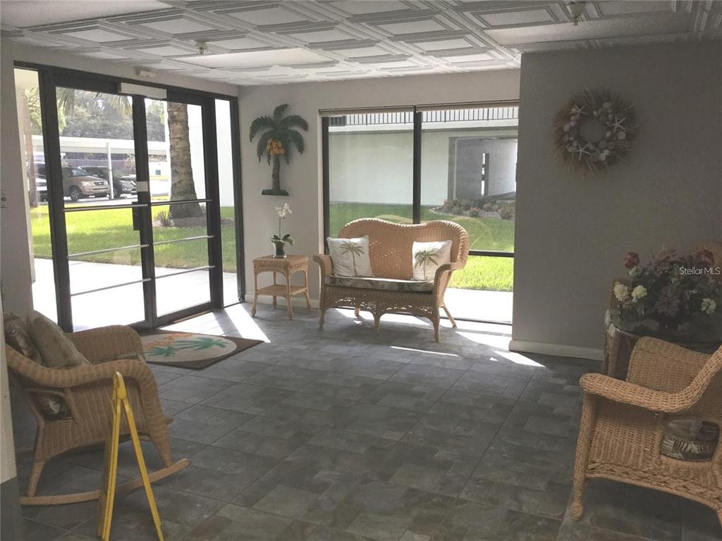 9860 62nd Avenue North, Unit 1014 St. Petersburg, FL 33708 - Photo 10 of 68 a living room with furniture and a floor to ceiling window
